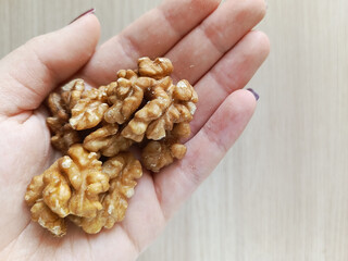 A handful of walnuts in my hand. The daily dose of nuts per day. Nuts in the diet.