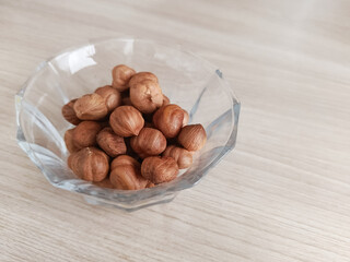 Amino acids in hazelnuts. Hazelnuts in a glass cup on a white background. Fats, proteins, and...
