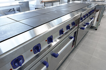 Stainless steel commercial griddles arranged in a modern kitchen with ample workspace for food preparation