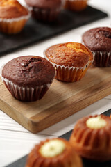 Freshly baked muffins displayed on wooden board in a cozy kitchen setting during afternoon