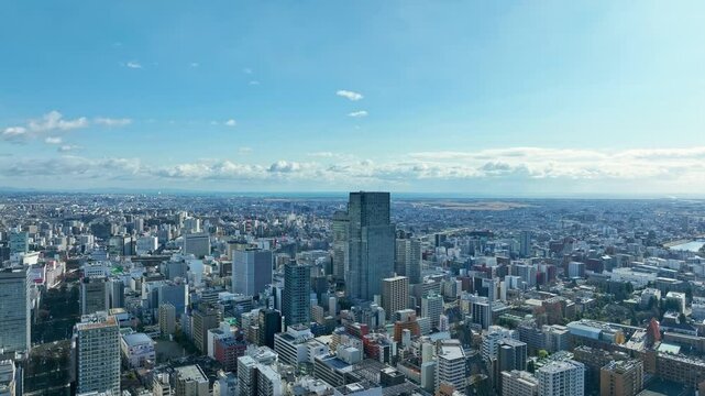 都市、空撮、ドローン、展望、青空、パノラマ、環境、時代、現代、風景、景色、景観、俯瞰、地平線、迫力、ダイナミック、絶景、インパクト、広角、広大、ハイアングル、上から見た、見下ろす、社会、都会、建設、建築、ビル、ビル群、不動産、高層ビル、摩天楼、日本、町並み、街、観光、旅行、コピースペース、昼間、晴れ、将来、未来、天気、ビジネス、産業、下降、遠近感、60p、パース、降下