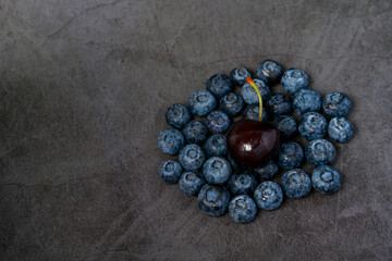 Closeup of blueberries and cherries on dark background.