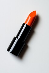A striking orange lipstick in a black tube, ready to enhance any look.