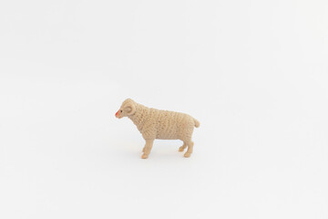 A single sheep toy on a white background with copy space