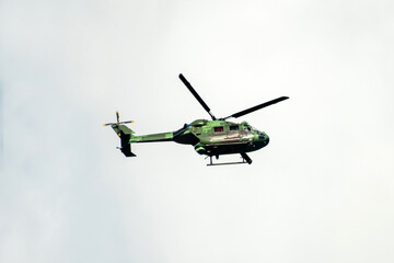 Helicopter is flying on isolated sky in mid-air background.