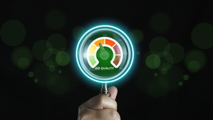 Hand holding a magnifying glass to check the good air quality at the green level safe from...