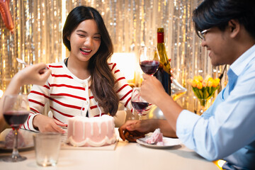 A birthday celebration with friends. A cake with candles is being served. Festive atmosphere with decorations, snacks, and happy people enjoying the party. Friends eating cake at birthday party.