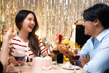 A birthday celebration with friends. A cake with candles is being served. Festive atmosphere with decorations, snacks, and happy people enjoying the party. Friends eating cake at birthday party.