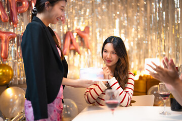 Group of Happy young Asian people friends enjoy and fun celebration birthday party at home dinner party. Beautiful woman excited with birthday cake and blowing candle.