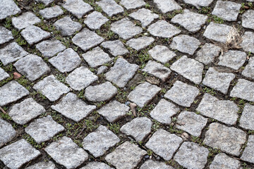 Sidewalk. Old cobblestone way. Wallpaper. Cobblestone road. Brick surface background. Top view, above. Horizontal photo. 