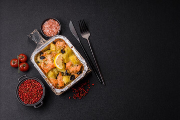 Baked salmon pieces with potatoes, cheese and olives