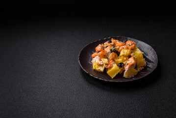 Baked salmon pieces with potatoes, cheese and olives