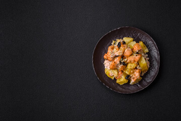 Baked salmon pieces with potatoes, cheese and olives