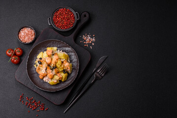 Baked salmon pieces with potatoes, cheese and olives