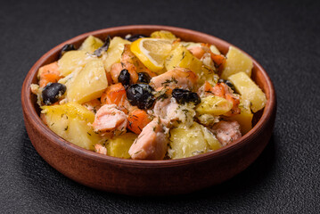 Baked salmon pieces with potatoes, cheese and olives