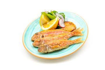 Delicious grilled red mullet fish with garnishes like lemon, greens and onions on white background