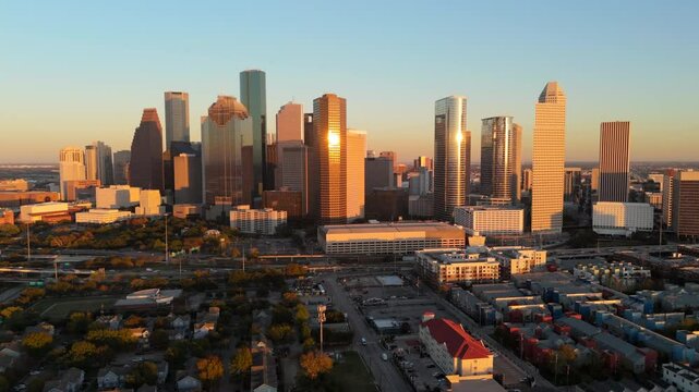 Cinematic aerial view of stunning downtown skyline of Houston, Texas, during a beautiful sunset, emphasizing citys remarkable architecture alongside its vibrant atmosphere, car freeway interchange 