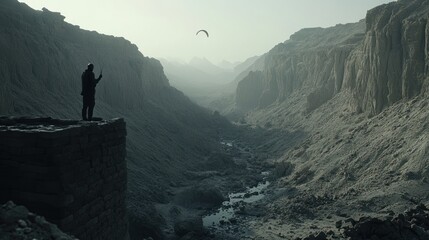 Solitary Figure on a Clifftop Overlooking a Desolate Canyon