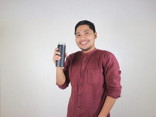 Handsome Asian man smiling while holding a black reusable bottle. show a positive vibe and confident expression