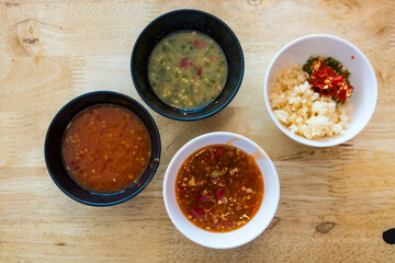 Sukiyaki dipping sauce and seafood sauce with minced garlic and chilli in black bowl