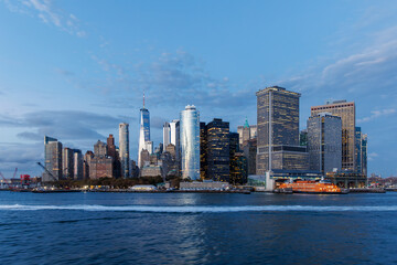 A vibrant sunset panorama of Manhattan downtown skyline, viewed from the river