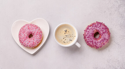 An assortment of vibrant donuts and a coffee cup perfect for a Valentines Day card