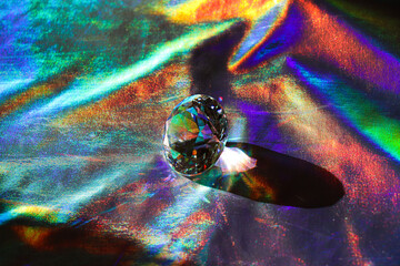 Obraz premium Holographic fabric texture. A diamond lies on a shiny fabric. Rainbow effect. Prism.