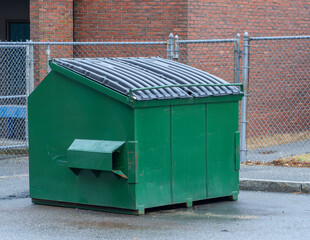 large green commercial dumpster for trash and recycling