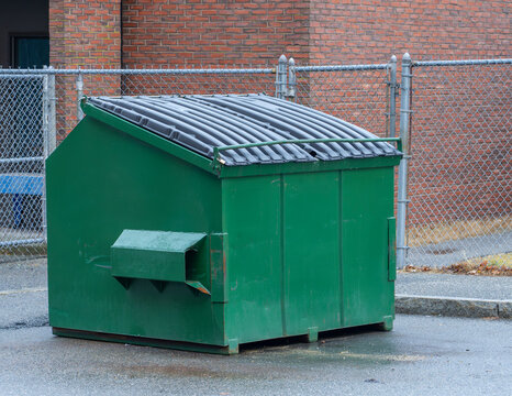 large green commercial dumpster for trash and recycling