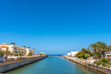 Canal flowing between buildings in la manga del mar menor, spain