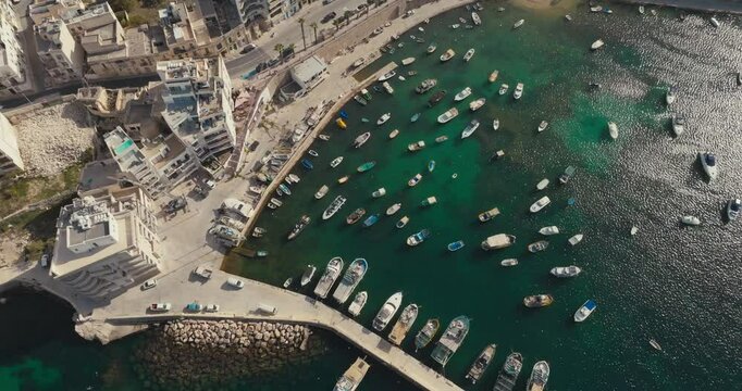 Beautiful Aerial Footage of Bugibba Marina in Malta Highlighting Mediterranean Coastline with Moored Yachts Boats and Stunning Tourist Cityscape. High quality 4k footage