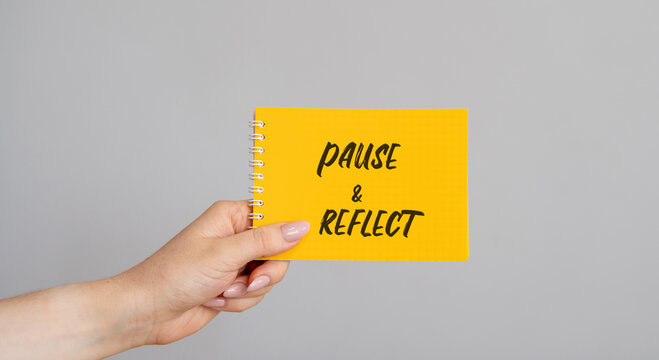 Notes Pause and reflect in a female hand. Stop, think, and assess a situation, experience, or decision before moving forward. Business and time management concept