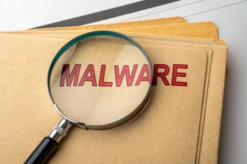 Magnifying glass over malware folder. Check and investigate, cybersecurity threat