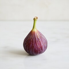 Obraz premium Ripe fig with soft purple skin resting on a marble surface under natural light