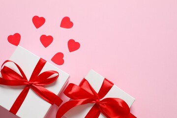 Gift boxes with red hearts on color  background