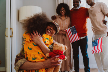Us Veteran woman homecoming. Young woman coming back to her family from military service for...