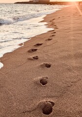 Footprints in the Sand on a Beach at Sunset.