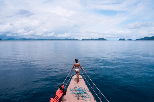 Young woman in bikini standing on the boat prow, Philippines