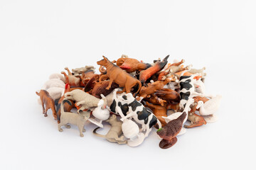 Pile of toy miniature mixed farm animals on white isolated background