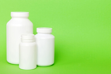 supplement pills with medicine bottle health care and medical top view. Vitamin tablets. Top view mockup bottle for pills and vitamins with green leaves, natural organic bio supplement, copy space