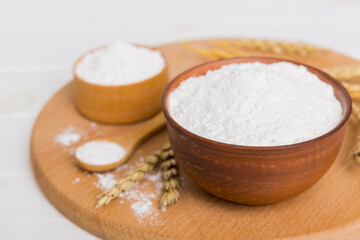 Flat lay of Wheat flour in wooden bowl with wheat spikelets on colored background. world wheat crisis