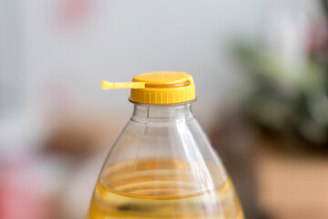 Yellow plastic cap for PET bottle with sunflower oil. New design with less plastic, the cap remains attached to the bottle after opening. Designed to reduce plastic waste.