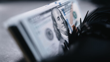 Automatic money counting machine sorts 100 dollar bills with an image of Benjamin Franklin....