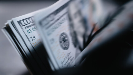 Automatic money counting machine sorts 100 dollar bills with an image of Benjamin Franklin....