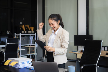 successful business woman with inspiration from their excellent financial results front at the desk.