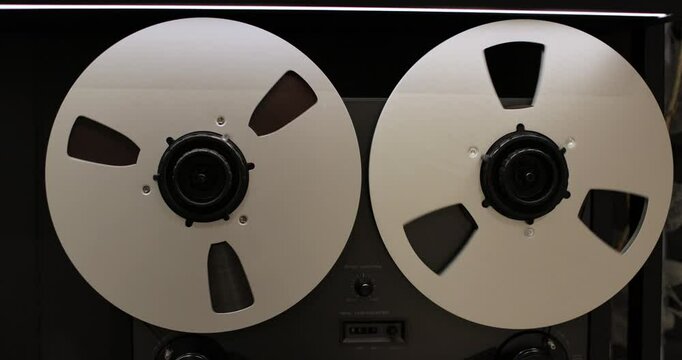 Reel to reel tape recorder playing. Rotating retro tape. Vintage music player close up. Old school concept.