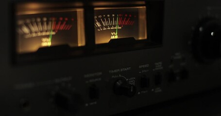 Analog VU meters on classic hi-fi reel-to-reel tape recorder. Retro sound level meter decibel meter in studio, vintage audio equipment.