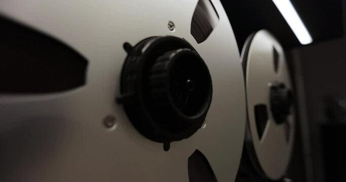 Reel to reel audio recorder tapes spinning. Rotating vintage music player close up. Retro tape. Old school concept.