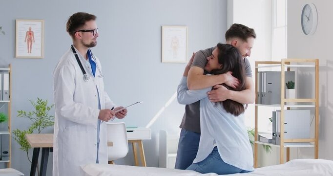 Happy young couple is consulting with a doctor about pregnancy or IVF during a hospital visit. They are planning and receiving care from a gynecologist, seeking guidance and consultation.
