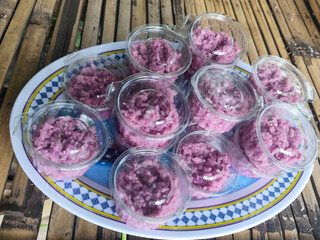 Sticky rice also known as sticky rice ribbon packed in plastic cups on bamboo table mats.